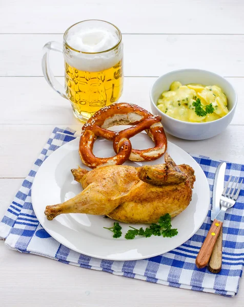 Meio frango assado, cerveja, pretzel e salada de batata — Fotografia de Stock