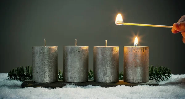 Enciende cuatro velas de adviento con fósforos —  Fotos de Stock