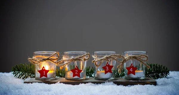 Vier Adventskerzen im Schnee lizenzfreie Stockbilder