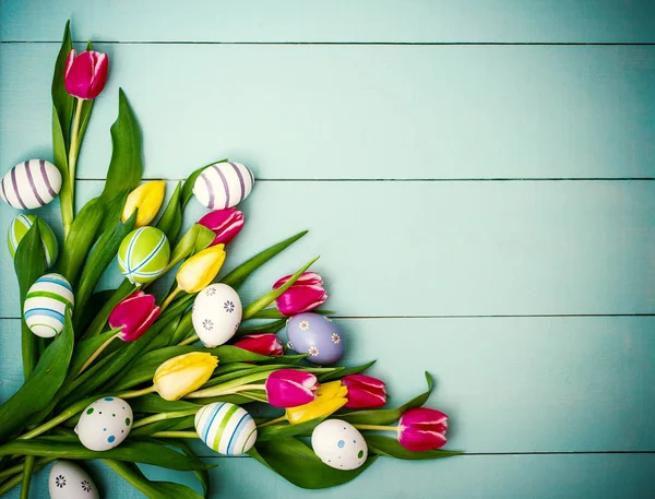 Tulipány s barevné velikonoční vajíčka, pohled shora — Stock fotografie