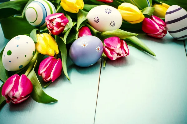 Tulipány s barevné velikonoční vajíčka — Stock fotografie