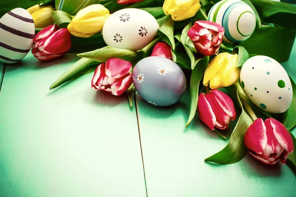 Tulipány s barevné velikonoční vajíčka — Stock fotografie