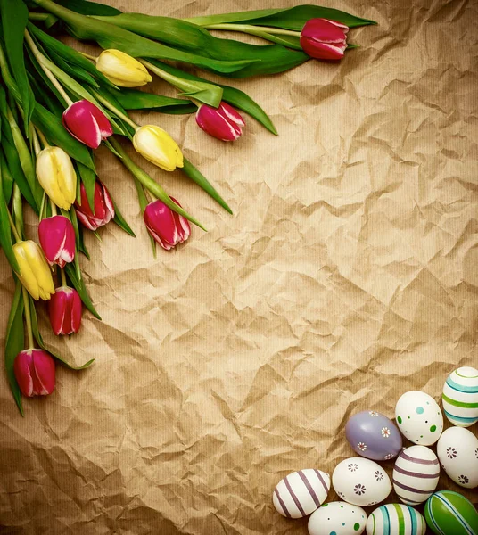 Ovo da ré, tulipas sobre papel de embrulho castanho amassado — Fotografia de Stock