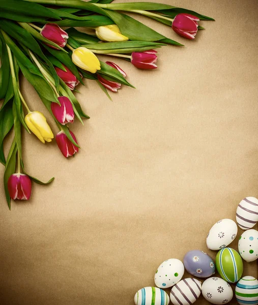 Východní vejce, tulipány na hnědý balicí papír — Stock fotografie