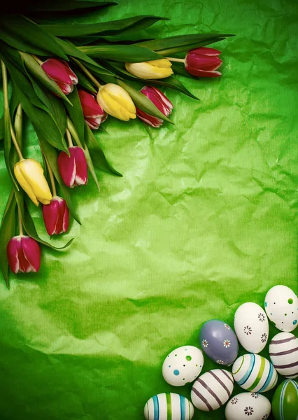 Ovo oriental, tulipas sobre papel de embrulho verde amassado — Fotografia de Stock