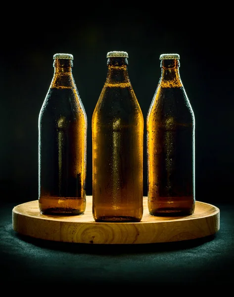 Trzy butelki zimnego piwa na drewniana Taca — Zdjęcie stockowe
