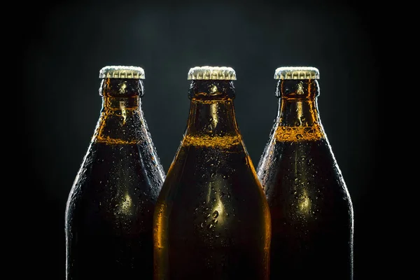 Trzy butelki zimnego piwa na czarny — Zdjęcie stockowe