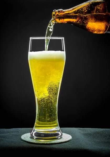 Copo de vidro de enchimento com cerveja dourada em close-up — Fotografia de Stock
