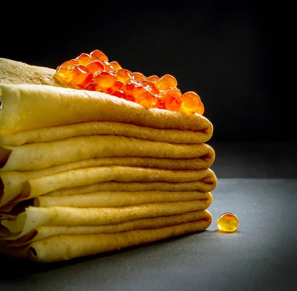 Red caviar on pancakes stack on black — Stock Photo, Image