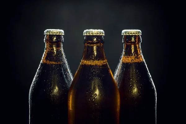 Trzy butelki zimnego piwa na czarny — Zdjęcie stockowe
