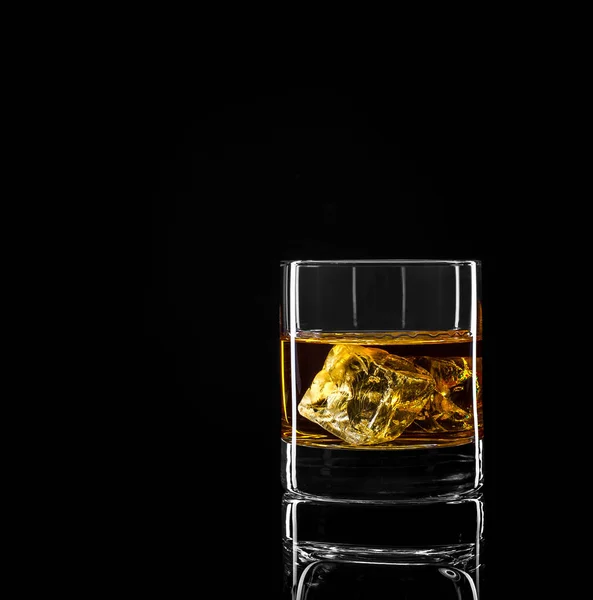 Whiskey glass with golden alcohol and ice cube — Stock Photo, Image