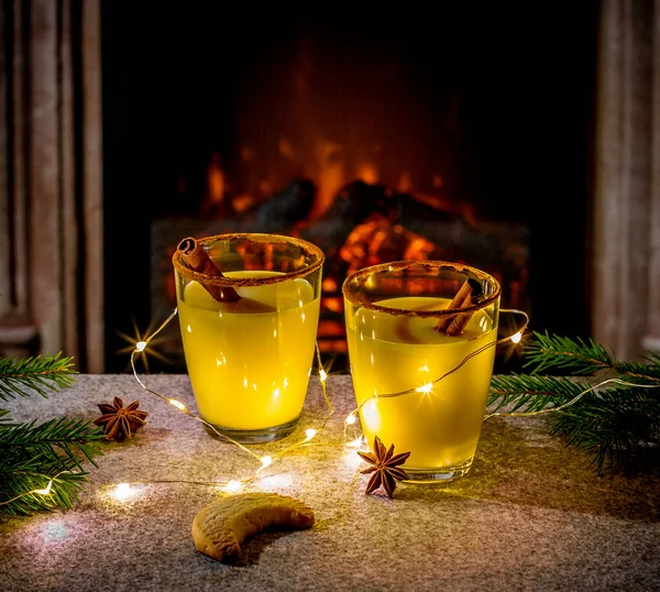 Two eggnog glasses at the fireplace — Stock Photo, Image