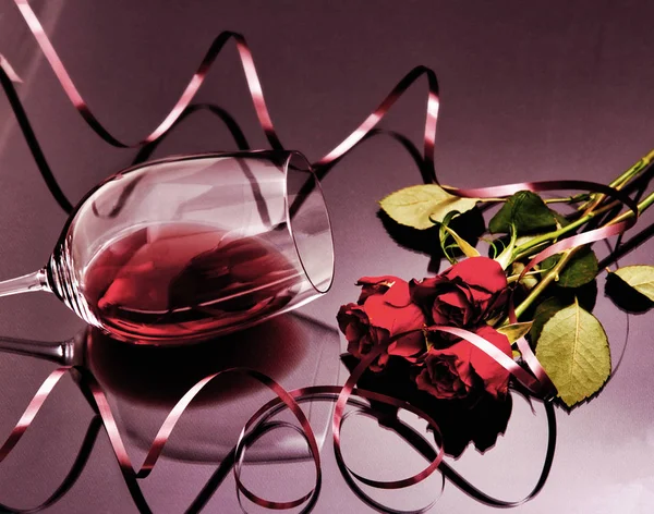 Kırmızı güller ve kırmızı şarap kadehi — Stok fotoğraf