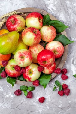 Taze Ahududu ve elma bir beton zemin üzerine eski ahşap plaka üzerinde. Sağlıklı kavramı. Doğal sağlıklı gıda.