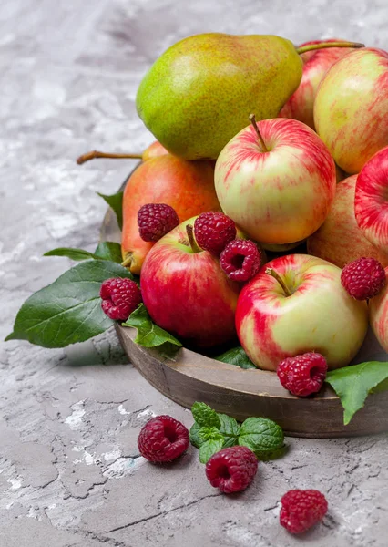 Fresh raspberries and apples on old wooden plate on a concrete background. Healthy concept. Natural healthy food. — Stock Photo, Image