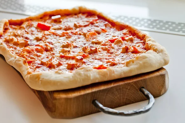 Pizza sobre tabla de cortar de madera — Foto de Stock