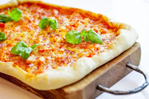 Pizza na drewnianą deską do krojenia — Zdjęcie stockowe