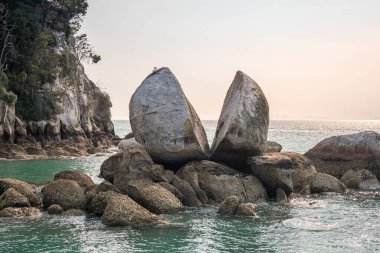 Gün batımlı Split Apple Rock, Abel Tasman Ulusal Parkı 'nın ünlü sahnesi.