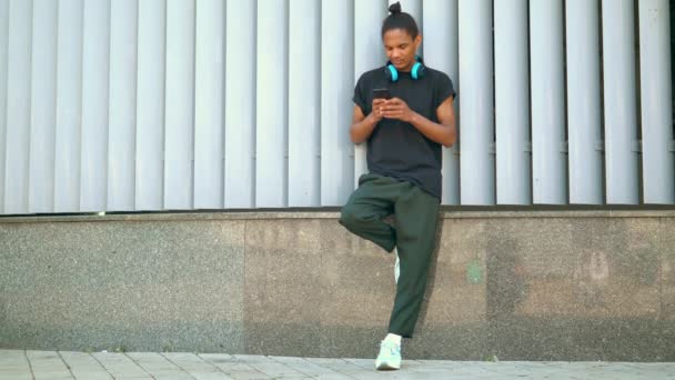 Portrait hipster guy holding smartphone in urban city — Stock Video