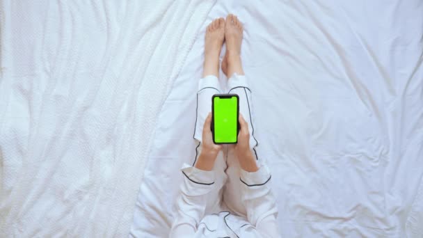 Вид сверху неузнаваемый женский прокрутка зеленый экран на смартфоне — стоковое видео