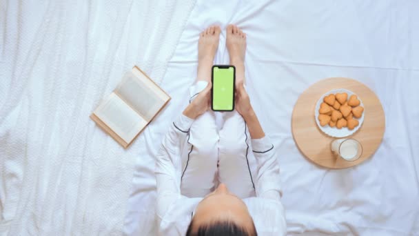 Ci-dessus vue femme caucasienne en utilisant mobile passer du temps au lit — Video