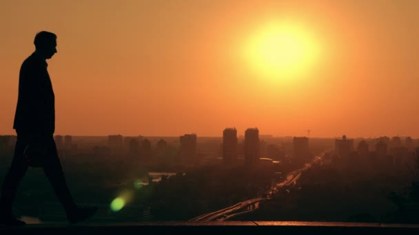Homem engenheiro em capacete caminha ao ar livre paisagem urbana ao nascer do sol — Vídeo de Stock