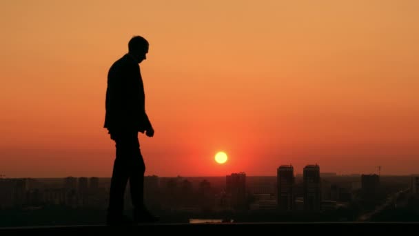 Успешный бизнесмен смотрит на город на рассвете — стоковое видео