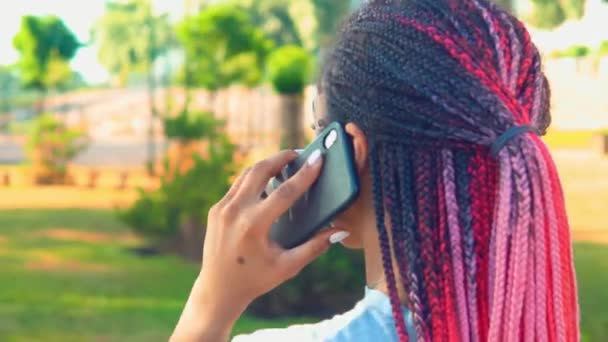 Zbliżenie wstecz widok Afryki amerykanka kobieta rozmawia przez telefon na zewnątrz — Wideo stockowe