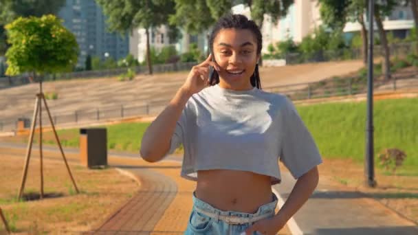 Afrikanische Amerikanerin geht telefonisch lächelnd glücklichen Lebensstil — Stockvideo