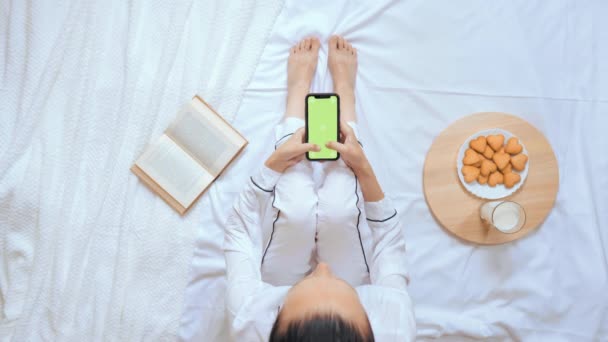 Вид зверху біла жінка тримає мобільний час у ліжку — стокове відео