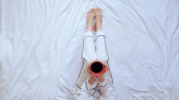 Sopra vista donna beve caffè si siede in camera da letto — Video Stock
