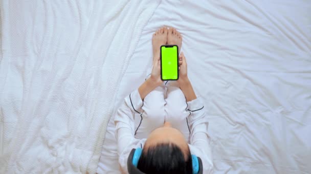 Sopra vista donna seduta sul letto tenendo smartphone — Video Stock