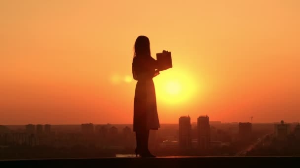 Žena s notebookem venku cityscape při východu slunce — Stock video