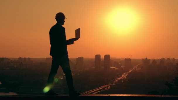 Homme d'affaires vêtu d'un casque au travail paysage urbain au lever du soleil — Video