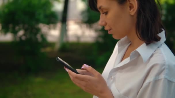 Perfil femenino camina uso móvil cámara lenta — Vídeo de stock