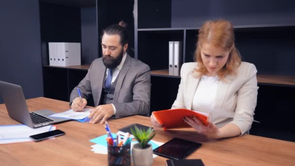 Medelålders affärspartner som arbetar med dokument på arbetsplatsen — Stockvideo