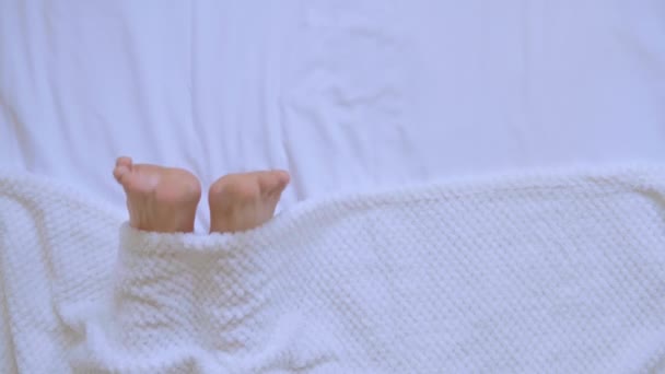 Top view male legs under a white blanket person — Stockvideo