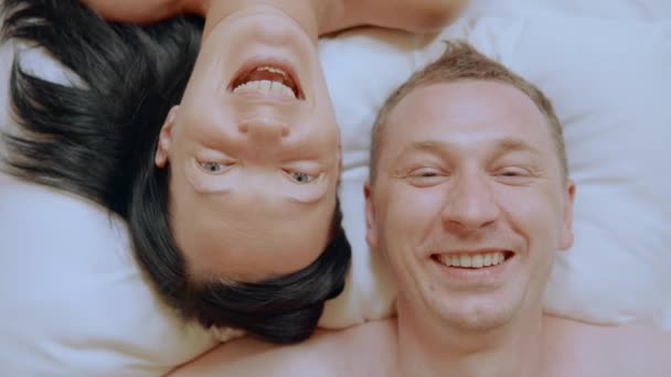 Close up smiling faces pair on the bed — Stock video