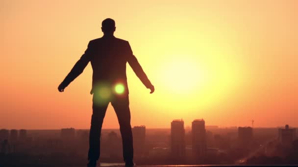 Чоловік святкує успіх на сході сонця в місті — стокове відео