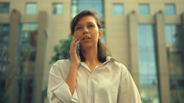 Zakenvrouw met behulp van mobiele wandelingen in het centrum — Stockvideo