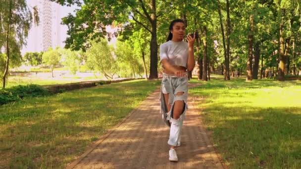 Vrouw houdt mobiele wandeling in de stad — Stockvideo