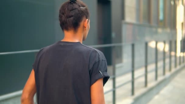 Nierozpoznawalny młodzieniec wychodzący na ulicę — Wideo stockowe