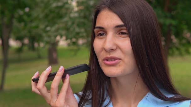 Jong brunette met behulp van app voice assistant smartphone — Stockvideo