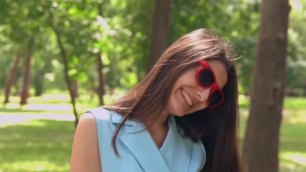 Grappig brunette poseren in zomer park — Stockvideo