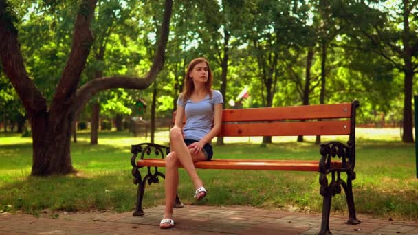 Женщина в ожидании друга в парке — стоковое видео