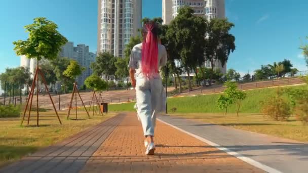 Terug uitzicht gemengde ras vrouwelijke wandeling buiten met mobiele telefoon — Stockvideo