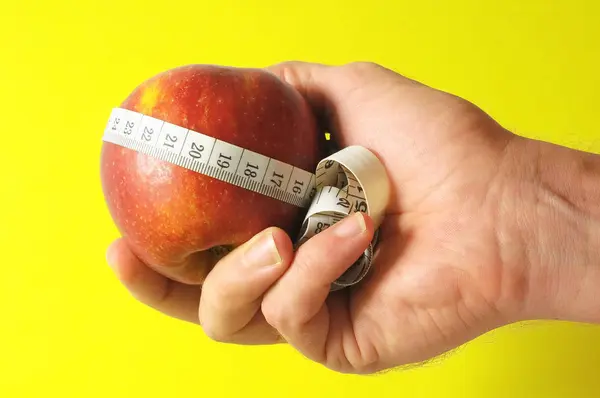 Diet Apple och mätare på handen — Stockfoto