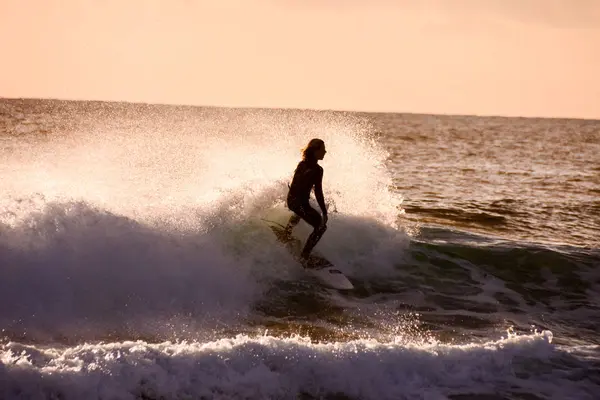 Surfer bij zonsondergang op een rustige oceaan — Stockfoto