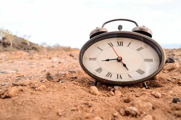 Relógio analógico clássico na areia — Fotografia de Stock