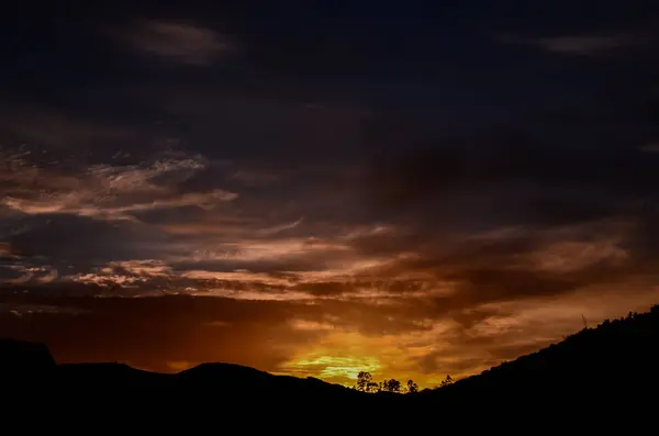 Soleil derrière une silhouette de montagne — Photo